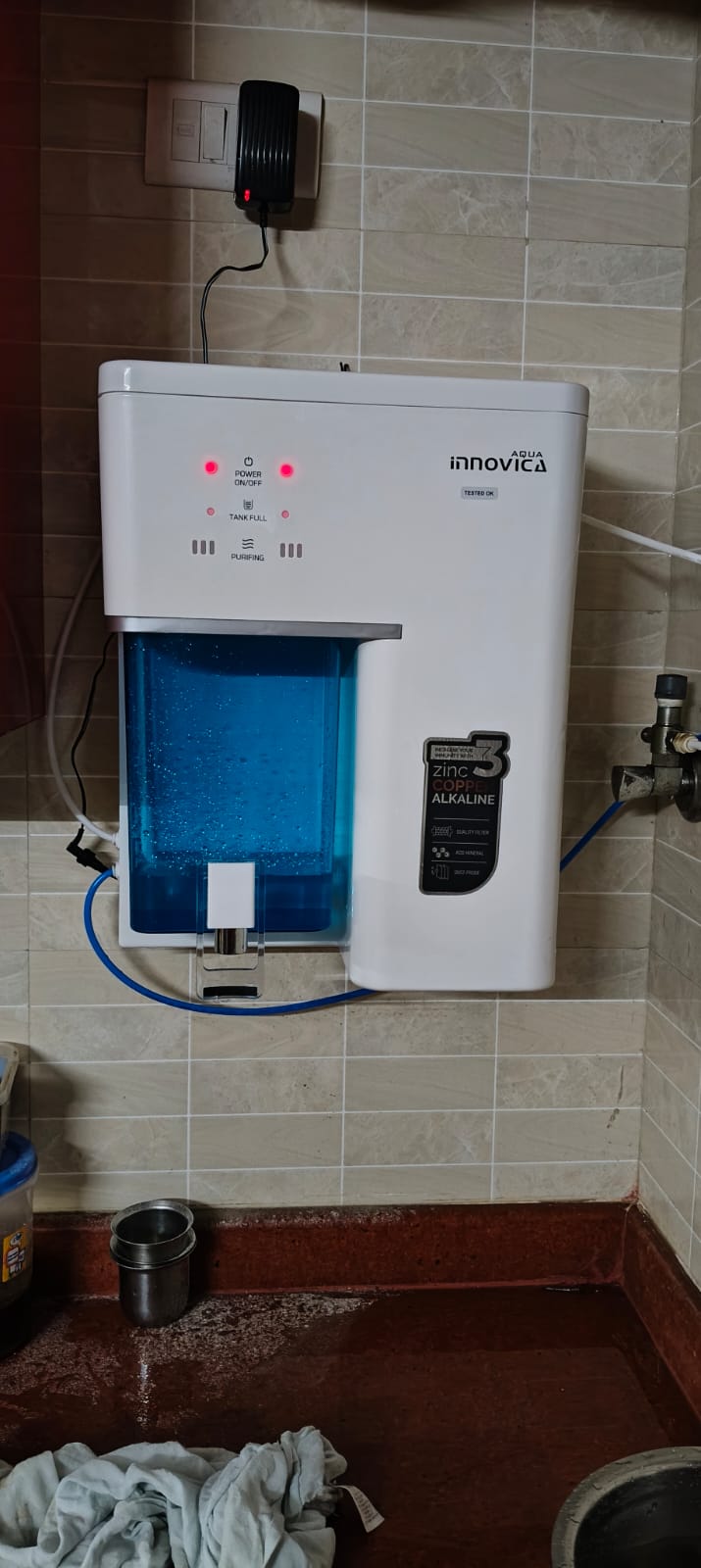 Technician mounting a new RO purifier on a kitchen wall
